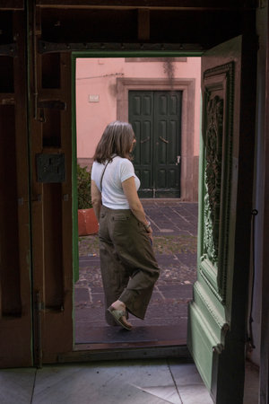View of a woman outside a doorway in the town of  Bosa which is situated about two-thirds of the way up the west coast of Sardinia, Italyのeditorial素材