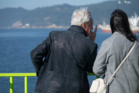 Tourists on a ferry ship travelling along the ocean coastline from Setubal across the water to Costa de Gale, Portugalのeditorial素材