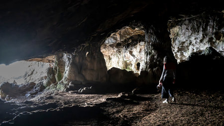 A woman walking through a cave at Lapa de Santa Margarida, SÃ£o LourenÃ§o, SetÃºbal, Portugalのeditorial素材