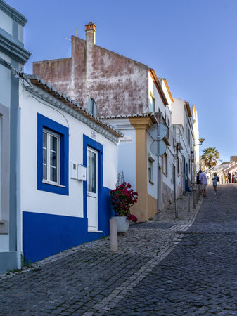 Slopped narrow cobblestone road through the town of Lagos in southern Portugal's Algarve region. Itâs known for its walled old town, cliffs and Atlantic beachesのeditorial素材