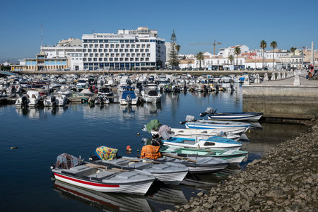 Boats docked along the coastline of Faro which is the capital of southern Portugalâs Algarve region. The cityâs neoclassical Arco da Vila is on the site of a gate that was part of the original Moorish wallのeditorial素材