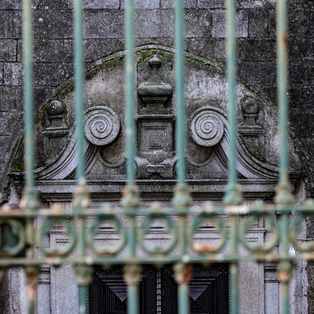 Carved design above the doorway of a building, as seen through a wrought iron fence in Silveiras, Alentejo region, Evora, Portugalのeditorial素材