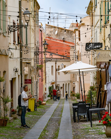 People on a street in the city of Alghero which is on the northwest coast of Sardinia, Italy.