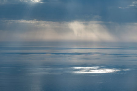 Mist falling from clouds over the ocean off the coast of Sardinia, Italy