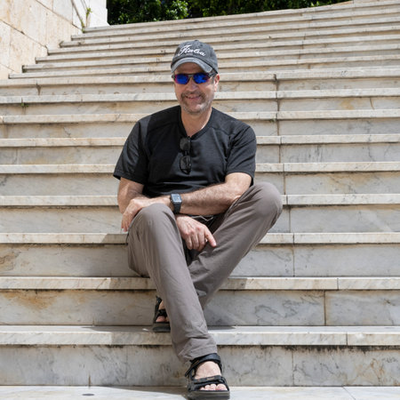 Male tourist sitting on stairs, Bastione di Saint Remy, Cagliari, Sardinia, Italy