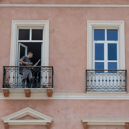 Man standing on a balcony in the City of Cagliari, Sardinia, Italy