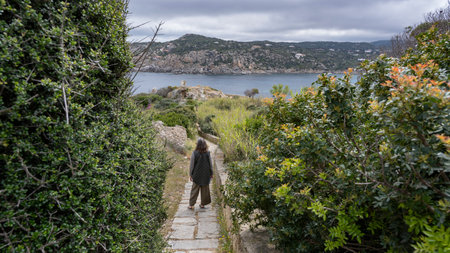 Woman hiking along a walkway path along the shoreline, Santa Teresa Gallura, Sassari, Sardinia, Italyのeditorial素材