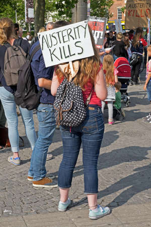 Bristol, UK - July 8, 2015: An anti-austerity demonstrator holds a placard with the slogan âAUSTERITY KILLSâ.のeditorial素材