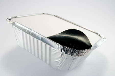 Square silver foil tray with lid slightly open on a white backgroundの写真素材