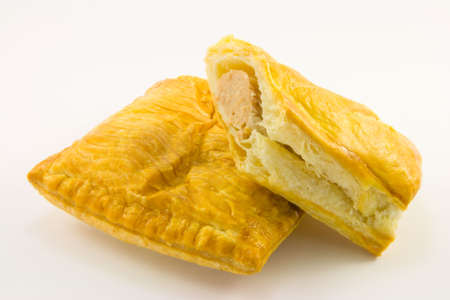 Single golden pasty with single sausage roll on a white backgroundの写真素材