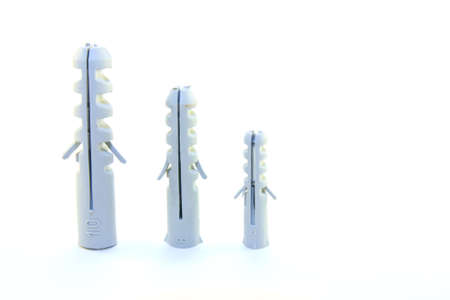 Three different size grey wall plugs on a white backgroundの写真素材