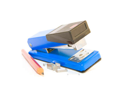 Single blue,chrome and black stapler with staples and pencil on a white backgroundの写真素材