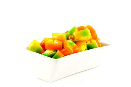 Red, yellow and green chillis chopped in a dish on a white backgroundの写真素材