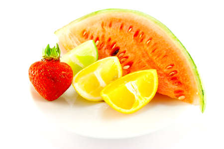 Lemon, lime and orange wedges with a red ripe strawberry and slice of juicy watermelon with a white backgroundの写真素材