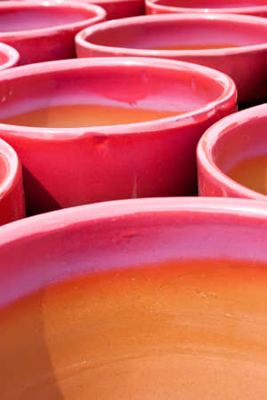 a collection of bright red and purple glazed flower potsの写真素材