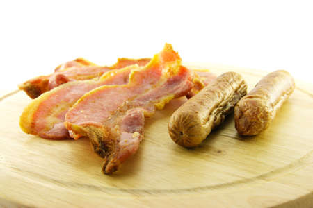 Delicious cooked breakfast items on a wooden plate on a white backgroundの写真素材