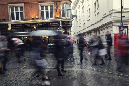 a busy citystreet showing urban lifestlye with shadow and silhouette people movingのeditorial素材