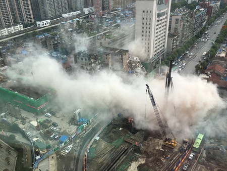 WUHAN, CHINA - AUGUST 17 2017: dust cloud spreading in city street after a building collapse during...