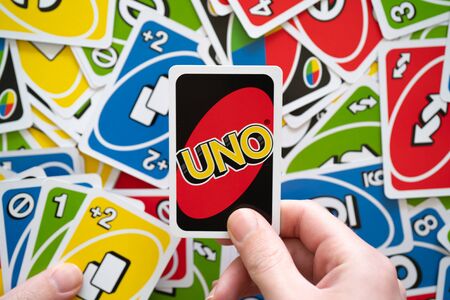 6 April 2019, Wuhan China : Man hand holding Uno game card showing the reverse of the card with Uno logoのeditorial素材