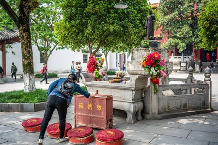 25 April 2018, Wuhan China : Chinese Woman offering money to a goddess statue at Guiyuan Buddhist temple in Wuhan Hubei Chinaのeditorial素材