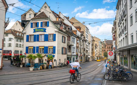 Basel Switzerland, June 29, 2020: Woman speeding on a bicycle and tramline and ancient houses street view in Basel old town Switzerlandのeditorial素材