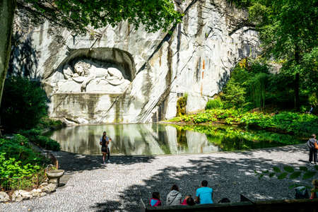 Lucerne Switzerland, June 29, 2020: Wide angle view of Lion monument and pool with tourists around...