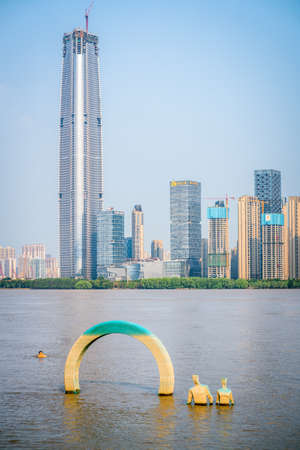 Wuhan China, August 30, 2020: Vertical view of Wuhan skyline in summer 2020 including under construction supertall Greenland center and flooded Yangtze riverbanks in Wuhan Hubei Chinaのeditorial素材