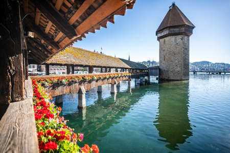 Lucerne Switzerland, June 30, 2020: Chapel bridge with flowers view and blue sky in Lucerne...