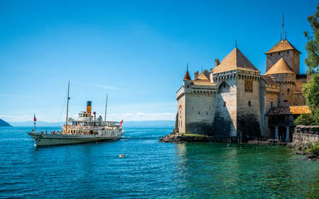 Veytaux Switzerland, 4 July 2020: Montreux touristic steamboat on Lake Geneva and Chillon castle view with clear blue sky in Vaud Switzerlandのeditorial素材