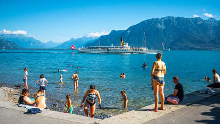Vevey Switzerland, 4 July 2020: People swimming in Lake Geneva from Vevey beach and touristic...