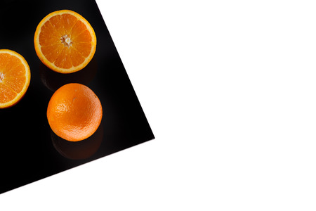 Orange on Black Sheet Isolated on whiteの写真素材