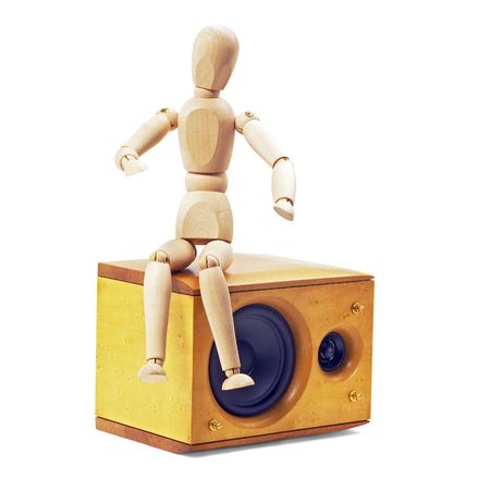 wood mannequin sitting on a speaker isolated on white backgroundの写真素材