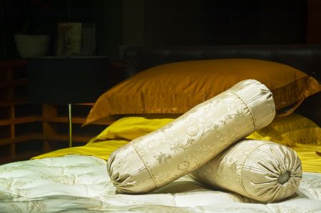 two cylindrical pilows over a bedの写真素材