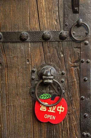 finely decorated chinese wooden old door with a red open signの写真素材