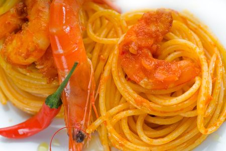 italian spaghetti pasta and fresh spicy shrimps sauce over whiteの写真素材