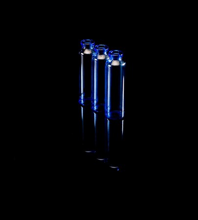 blue glass vials over black background backlitの写真素材