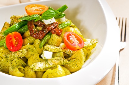 fresh lumaconi pasta and pesto sauce with vegetables and sundried tomatoes,tipycal italian foodの写真素材