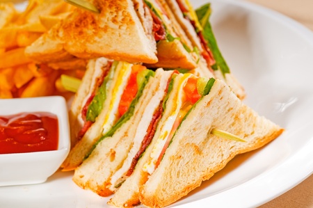 fresh triple decker club sandwich with french fries on sideの写真素材