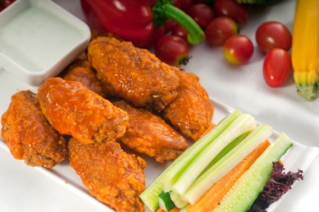 classic  buffalo chicken wings served with fresh pinzimonio and vegetables on backgroundの写真素材