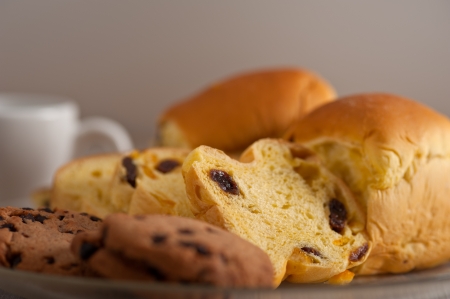 selection of sweet bread and cookies for breakfast with empty coffee cup on side