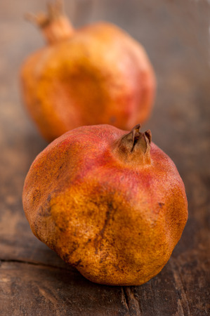 dry and old pomegranates over rustic wood tableの写真素材