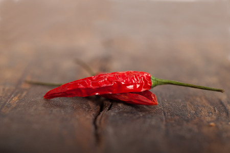 dry red chili peppers over old wood table 
