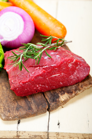 fresh raw beef cut ready to cook with vegetables and herbsの写真素材