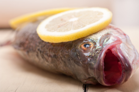 fresh whole raw fish on a wooden table ready to cookの写真素材