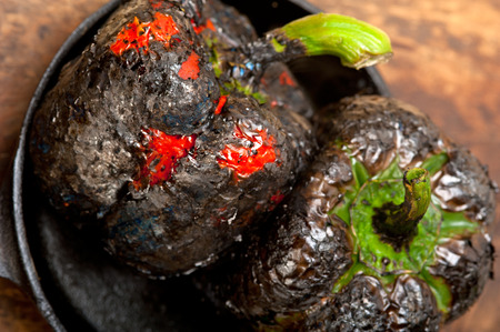 three fresh bell peppers charcol scorched  over old wood table on a skillettの写真素材