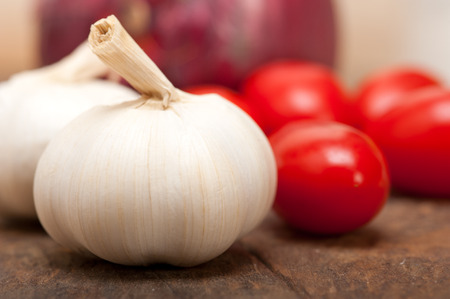onion garlic and tomatoes foundations of Italian food on rustic tableの写真素材