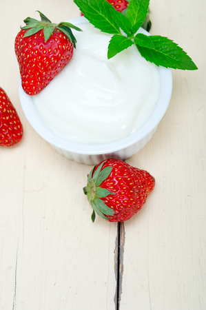 organic Greek yogurt and strawberry over white rustic wood tableの写真素材