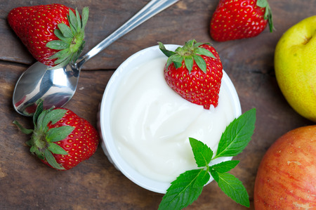 fresh fruits and whole milk yogurt on a rustic wood tableの写真素材