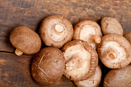 fresh shiitake mushrooms on a rustic wood tableの写真素材