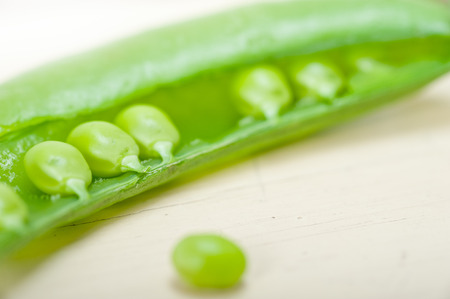 hearthy fresh green peas  over a rustic wood tableの写真素材